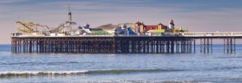 Brighton : jetée, mer calme, ciel dégagé, plage de galets.