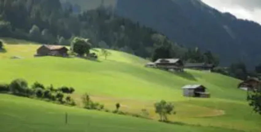 Gstaad-Saanen : Collines verdoyantes et maisons dispersées.