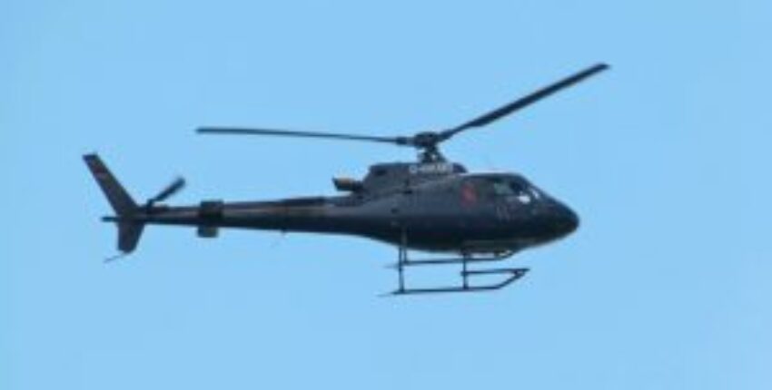 Hélicoptère noir ECUREUIL AS350 en vol clair.