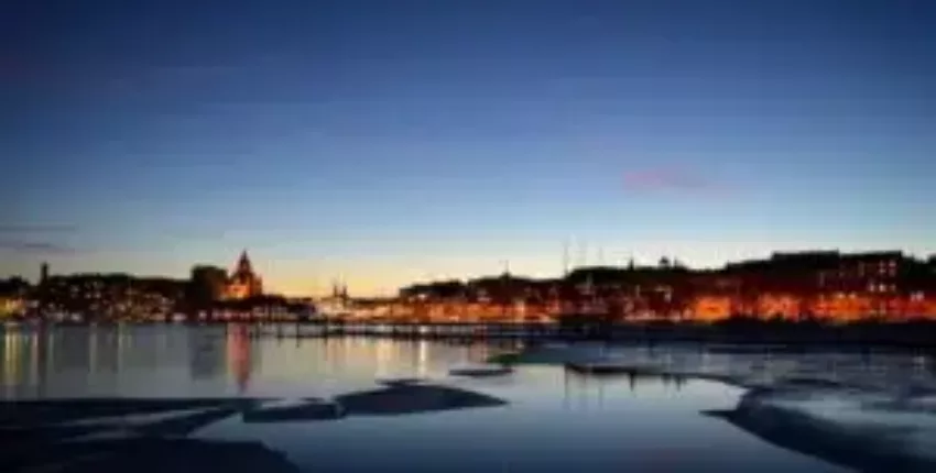 **privatjet mieten nach Helsinki: Bâtiments au crépuscule reflétés dans une rivière**