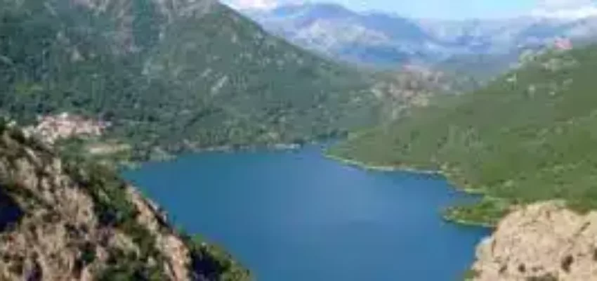 **location jet privé** : Lac tranquille entre montagnes verdoyantes et ciel bleu.