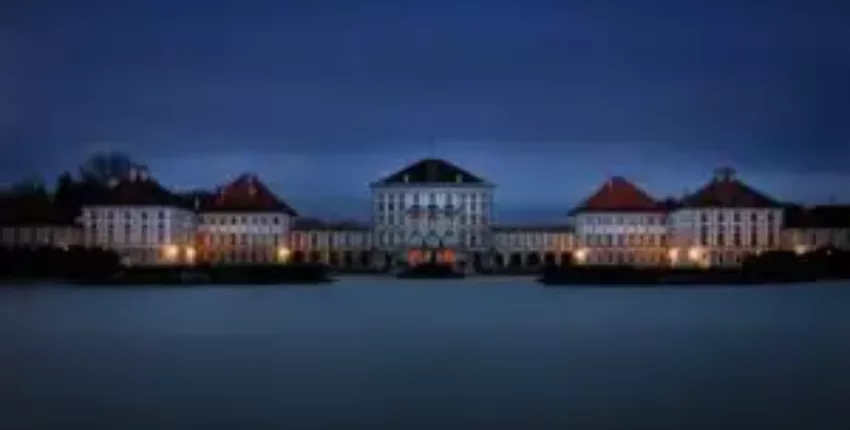 Jet privé Munich : Palais illuminé la nuit, eau devant.